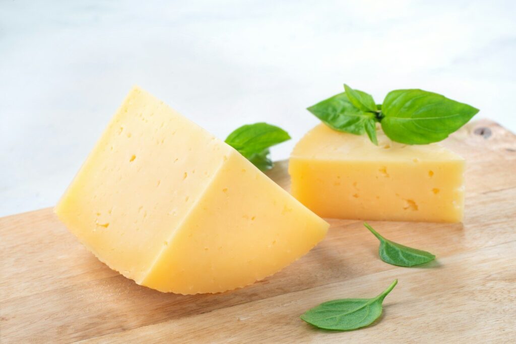 a piece of cheese with a leaf on top of it